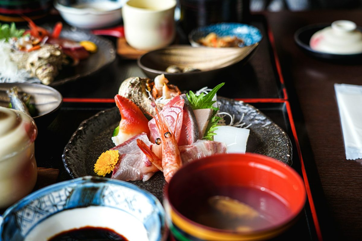 For Kaiseki Yu-zen Hashimoto: A sashimi course on a lacquered tray with a red soup bowl and blue-and-white dishes