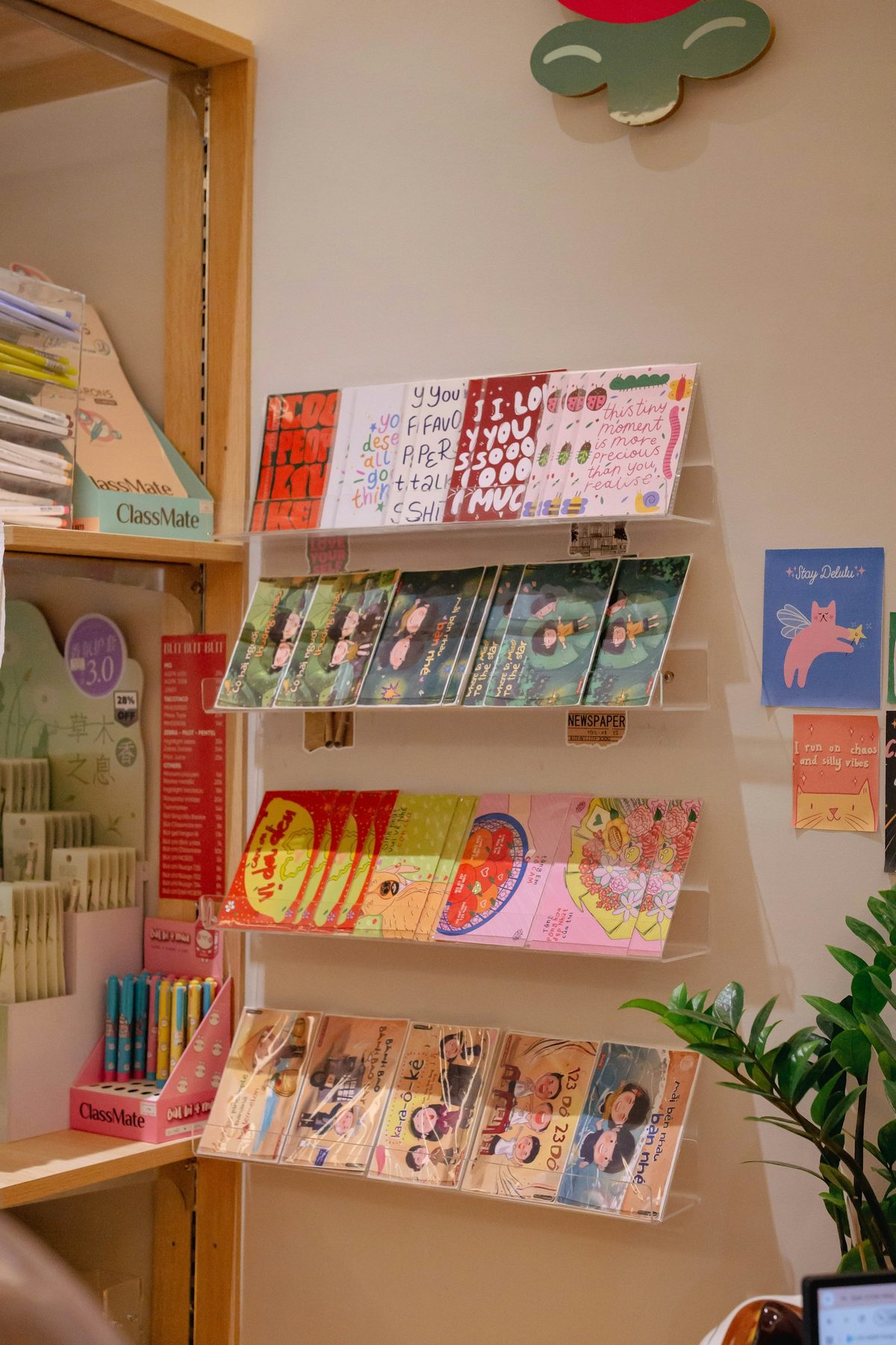For Kid Icarus: Wall racks of colourful greeting cards and prints in a small shop (portrait).