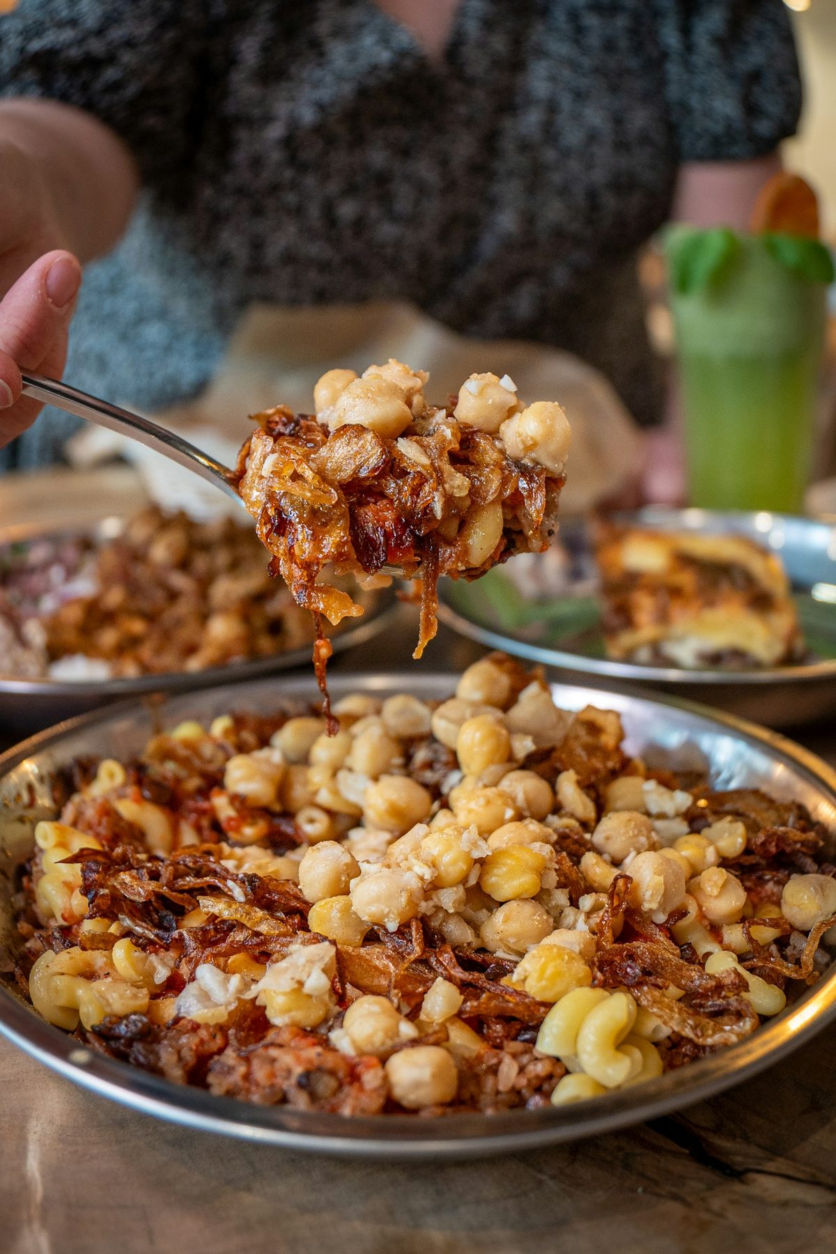 For Maha's: A spoonful of koshari (lentils, chickpeas, pasta, fried onions) lifted over the pan